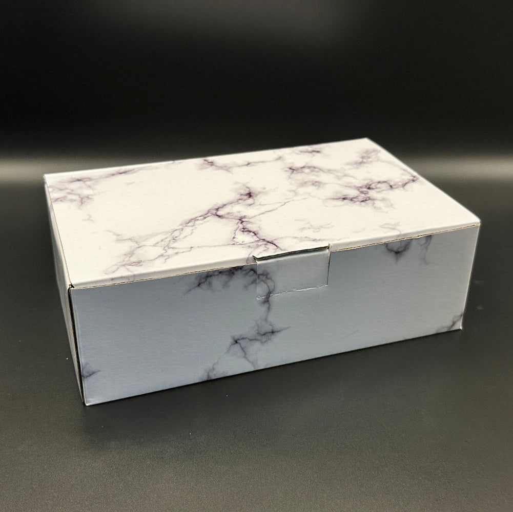 Marble-patterned gift box on a dark surface
