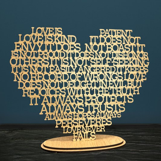 Wooden heart-shaped sculpture with engraved text on a dark background
