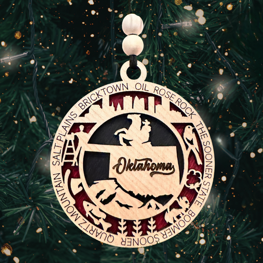 Round multi-layer laser cut ornament featuring an outline of the state of Oklahoma and a number of descriptive words.