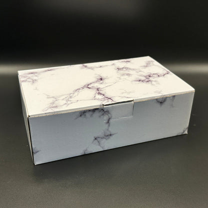 Marble-patterned gift box on a dark surface