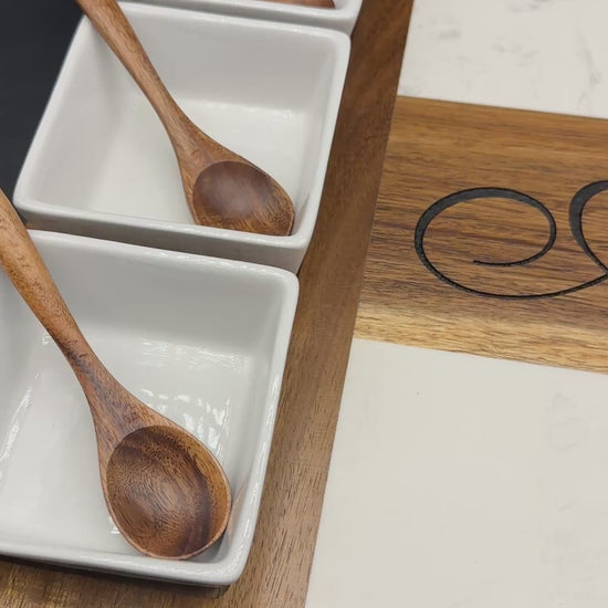 Panning view of personalized marble and acacia wood charcuterie board with custom engraving