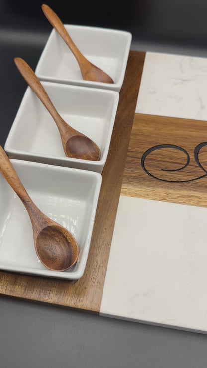 Panning view of personalized marble and acacia wood charcuterie board with custom engraving